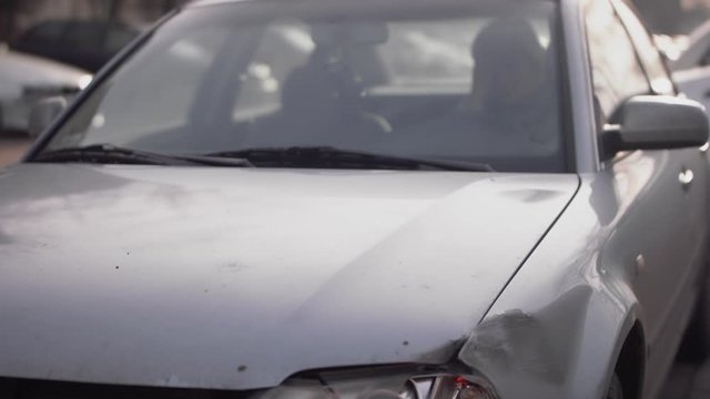 Tilt Up From Broken Car Lights To Reveal Women Driver Stressed On Phone Inside. Slow Motion