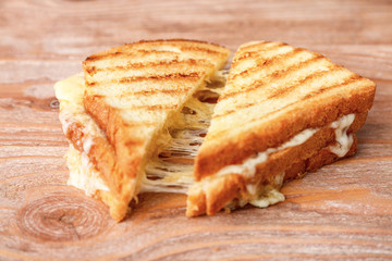 Tasty sandwiches with cheese on wooden background