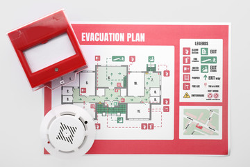 Evacuation plan, smoke detector and manual call point on white background