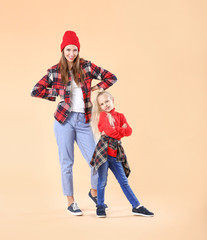 Woman and her little daughter against color background