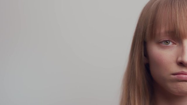 Close shot of the half-face of a woman on a white background.