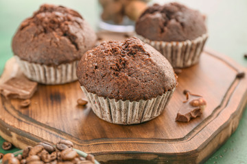 Tasty chocolate muffins on wooden board
