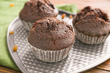 Plate with tasty chocolate muffins on table, closeup