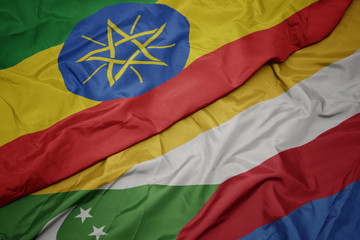 waving colorful flag of comoros and national flag of ethiopia .
