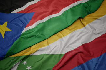waving colorful flag of comoros and national flag of south sudan.