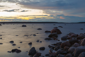 Baltic sea rocky shore at colorful sunset.
