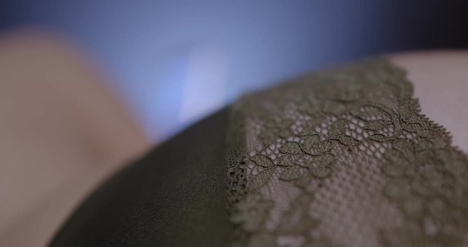 Close up of young woman in sexy lingerie chatting on the smartphone. Racking focus reveals lace design. Online dating concept.