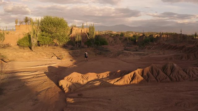 Aerial flies over a Guy in the Tatacoa Desert during Sunset, Colombia.