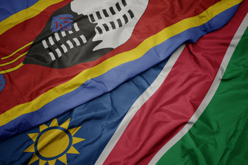 waving colorful flag of namibia and national flag of swaziland.