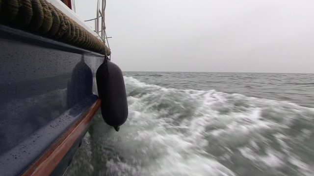 Side of a motorboat​ low angle POV, cruising at sea on an overcast day