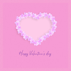 Heart made up of spring flowers on a pink background. Happy valentines day background.