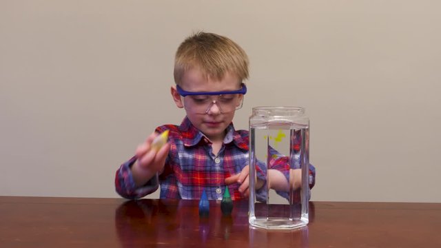 Little boy mixing colors together for a science experiment.