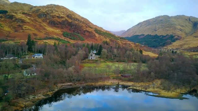 Aerial shot flying in from loch to church, Scotland
