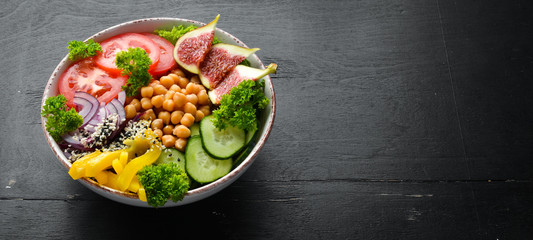 Healthy vegetable buddha bowl lunch with chickpeas, figs, cucumber, tomatoes and onions. Dishes...