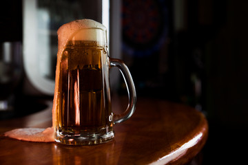 Beer in a Mug with Foam Resting on a Wooden Surface with Blank Space for a Logo or Text