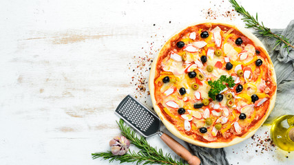 Traditional Italian pizza with crab sticks and olives. Top view. free space for your text. Rustic style. © Yaruniv-Studio