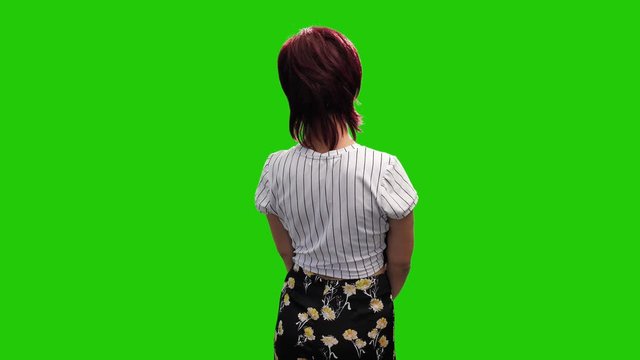Cheerful middle aged woman turning around on green screen