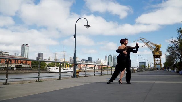 Two good looking tango performers dancing with passion in luxurious Puerto Madero neighborhood