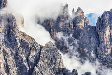Fototapeta na wymiar Huge rocky mountains view covered with clouds, Dolomites, Italy