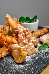 Close up view of deep fried fruits in breading served with caramel and strawberry jam