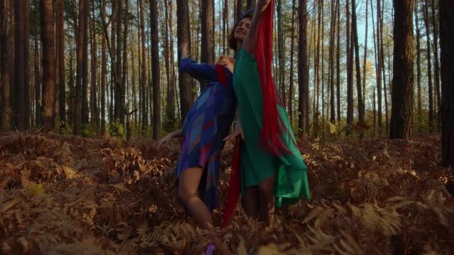 Moving Shot Of Two Women Dancing Sync In Miraculous Forest.