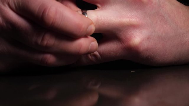 A man takes off his wedding ring and drops it on the table - concept: divorce, breakup, separation, cheating, adultery, infidelity