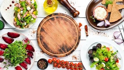 Food. Set of salads and dishes on white wooden background. Top view. free space for your text. Rustic style.