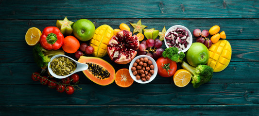 Background Organic food. Fruits, vegetables, beans and nuts on a blue background. Top view. Free space for your text.