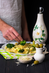 pasta with broccoli, olives and asparagus on a dark wooden background
