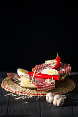 spicy meat sandwich with chili peppers on a dark wooden background