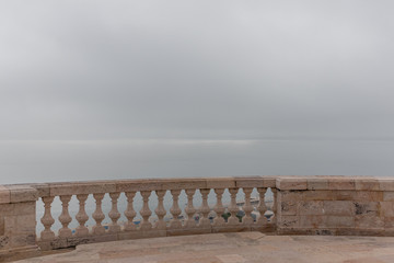 Empty marble railing facing the ocean on a foggy day, National Pantheon, Lisbon, Portugal
