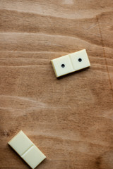 The game of dominoes. Pieces of dominoes on a brown wooden table background