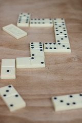 The game of dominoes. Pieces of dominoes on a brown wooden table background