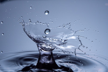 Water drops collision on a blue background. Abstract clear nature background