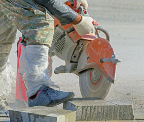 Worker cutting stone block by cutter machine