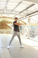 Obraz premium Young runner man stretching body before exercise run outdoor, hansom male jogger athlete training and doing workout in downtown city