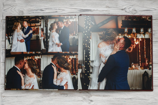  open family photobook on the beige wooden background. sample wedding  photo book close up. wedding photo album  close up .square open photo album on light background.