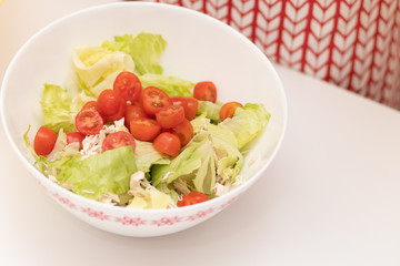 Salad with chicken, iceberg leaves, small tomatoes and croutons.
