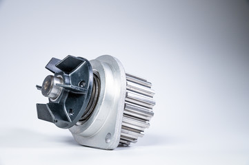 New metal automobile pump for cooling the engine of a water pump on a gray background. The concept of new spare parts for the car engine