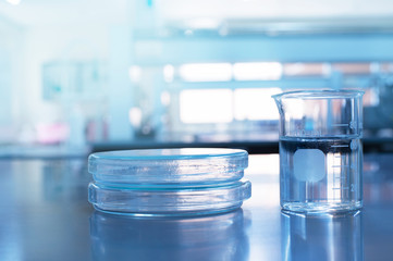 plate or petri dish with glass beaker with water in microbiology science laboratory background