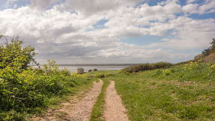 Fototapeta na wymiar Walking trail at Red Rock, Sutton, County Dublin on the east coast of Ireland. A martello Tower and Dublin Bay can be seen in the distance.