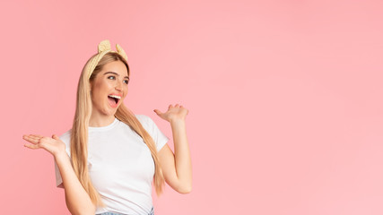 Amazed teenager looking aside spreading hands at studio