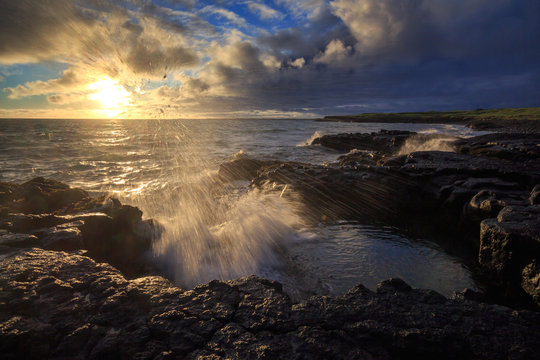 A rocky shore of solidified lava during sunset. © Uladzimir