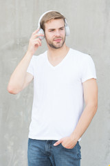 Noise Reduction. Modern and contemporary music. Wireless Earpiece. Handsome guy wear headphones...