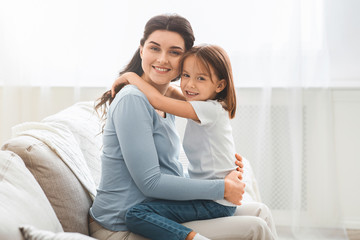 Portrait of pregnant woman and her little daughter hugging