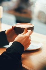 Fototapeta na wymiar Close up of female hands holding coffee mug
