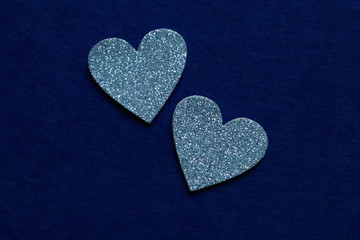 two silver hearts  on classic blue background in trendy color of year. Copy space.