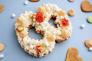 number 8 cake decorated with flowers, cream of cheese, marshmallows, Bizet on a blue background. International Women's Day postcard March 8