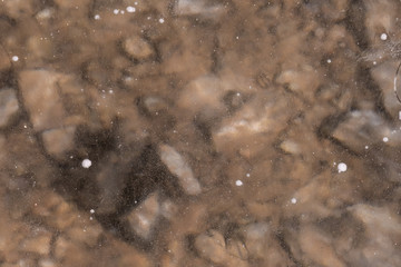 The texture of the rocky bottom and a layer of ice