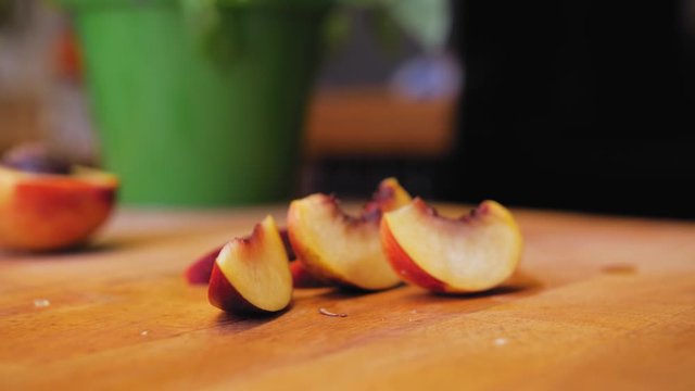 the cook cuts the nectarine on a wooden board